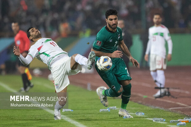 وحید امیری در حال تصاحب توپ از بازیکن تسم ملی فوتبال عراق در دیدار تیم های ملی فوتبال ایران و عراق است
