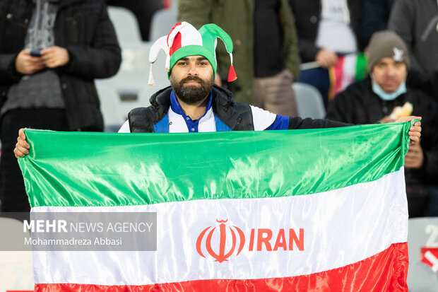 یکی از تماشاگران پرچم جمهوری اسلامی ایران را در دیدار تیم های ملی فوتبال ایران و عراق در دست دارد