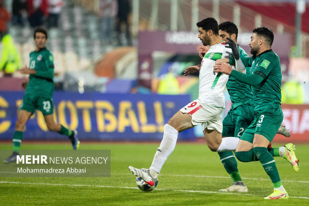 مهدی ظارمی در حال عبور توپ از مدافع های تیم ملی فوتبال عراق در دیدار تیم های ملی فوتبال ایران و عراق است
