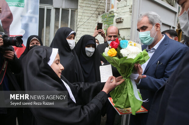  یکی از دانش آموزان مدرسه در حال خیر مقدم و اهدای گل به یوسف نوری وزیر آموزش و پرورش در مراسم آئین ملی گلبانگ انقلاب (نواختن زنگ انقلاب) است
