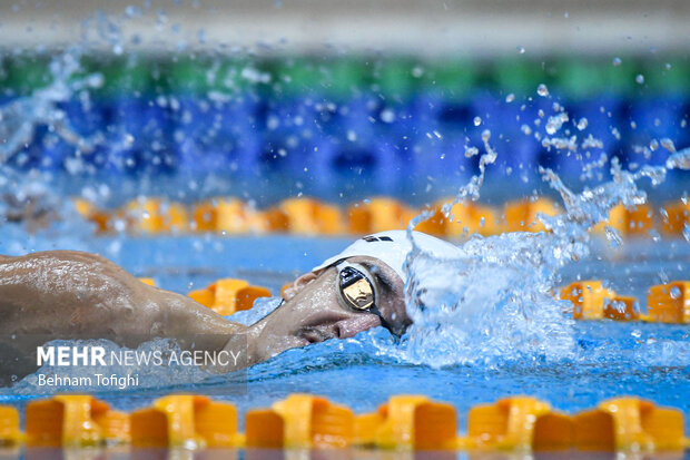 یکی از شناگران حاظر در مرحله دوم هجدهمین دوره لیگ برتر شنا در حال رقابت با سایر شناگران است