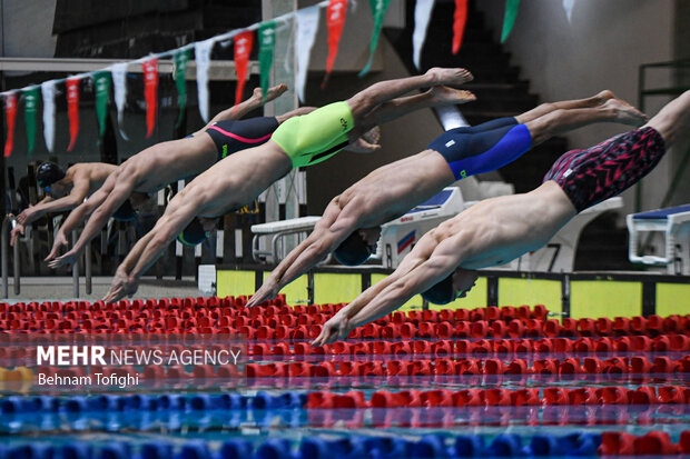 شناگران حاضر در مرحله دوم هجدهمین دوره لیگ برتر شنا کشور در حال شیرجه به استخر در خط شروع مسابقه خود هستند