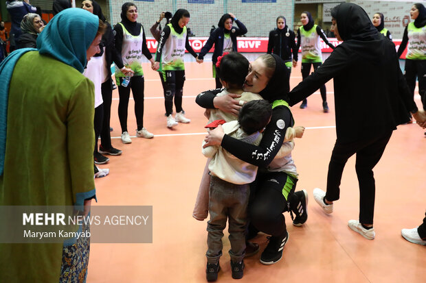 یکی از بازیکنان تیم والیبال سایپا در حال خوشحالی به همراه فرزند خود در پایان مسابقه برابر تیم سایپا است
