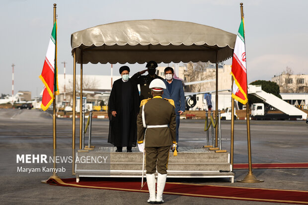 حجت الاسلام سید ابراهیم رئیسی رئیس جمهور و محمد مخبر معاون اول رئیس جمهور در حال ادای احترام به سرود جمهوری اسلامی ایران در مراسم بدرقه رئیس جمهور به کشور قطر هستند