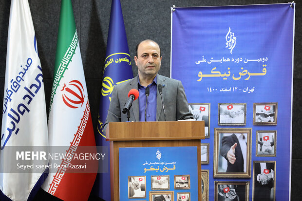  علی عاشوری مدیرعامل صندوق قرض‌الحسنه امداد ولایت در حال سخنرانی در مراسم دومین همایش ملی قرض نیکو است