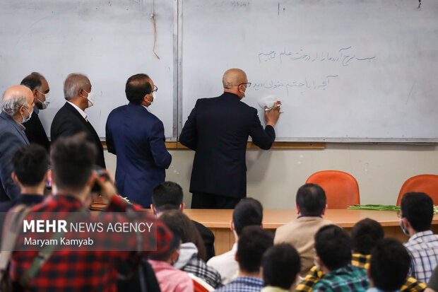 محمدعلی زلفی گل وزیر علوم در حال نوشتن شعر روی تخته در کلاس دانشجویان در دانشکده حقوق دانشگاه تهران است