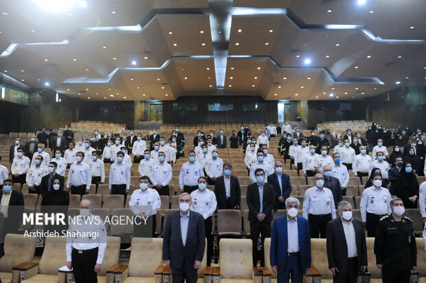 بهرام عین اللهی وزیر بهداشت کشور و حضار در مراسم تقدیر و تکریم خادمان سلامت نوروزی در حال ادای احترام به سرود جمهوری اسلامی ایران هستند