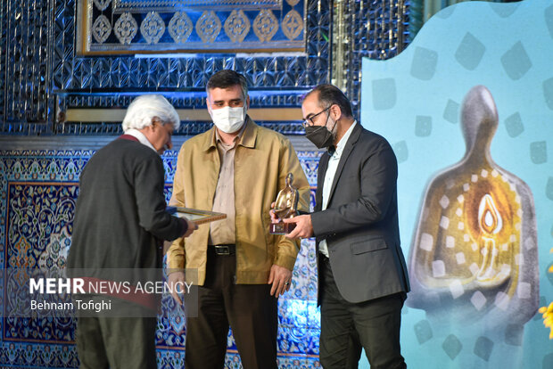 علی رمضانی مدیر عامل موسسه خانه کتاب و ادبیات ایران در حال تقدیر از یکی از برگزیدگان  هفته هنر انقلاب است 