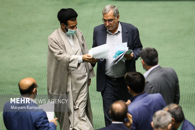 بهرام عین اللهی وزیر بهداشت در حال گفتگو با نمایندگان مجلس در جلسه علنی مجلس شورای اسلامی است