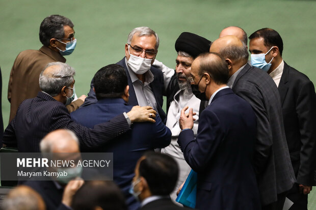 بهرام عین اللهی وزیر بهداشت در حال گفتگو با نمایندگان مجلس در جلسه علنی مجلس شورای اسلامی است