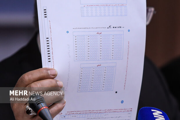دکتر عبدالرسول پورعباس رئیس سازمان سنجش و آموزش کشور در نشست خبری دفترچه سوال و جواب های کنکور 1401 را به خبرنگاران نشان می دهد