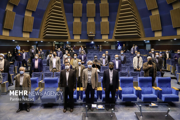 حاضرین در آیین پایانی دومین جایزه کتاب تاریخ انقلاب اسلامی در حال ادای احترام به سرود جمهوری اسلامی ایران هستند