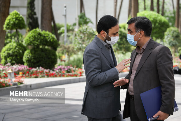  علی بهادری جهرمی سخنگوی دولت و علی سلاجقه رئیس سازمان محیط زیست در حال گفتگو با یکدیگر در حاشیه جلسه هیئت دولت هستند