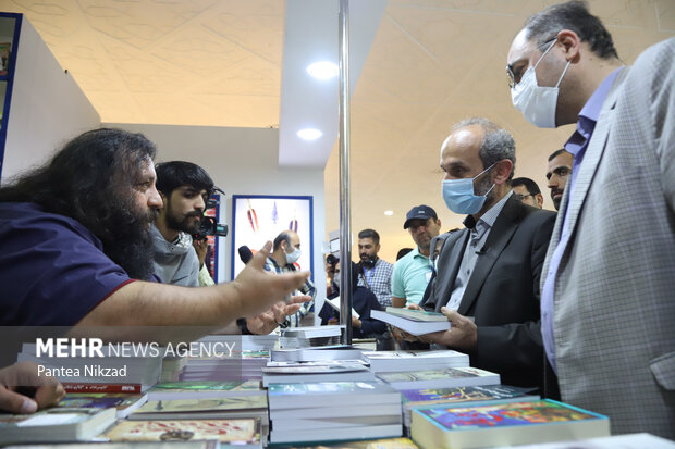 پیمان جبلی رئیس سازمان صدا و سیمای جمهوری اسلامی ایران در طی بازدید از سی و سومین نمایشگاه کتاب در حال گفتگو با یکی از ناشران است