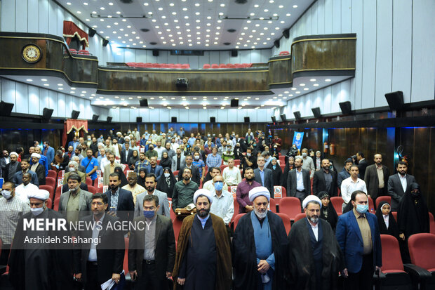 حاضرین در حال ادای احترام به سرود جمهوری اسلامی ایران در آیین اختتامیه نخستین سوگواره بین‌المللی "ملت امام حسین" هستند