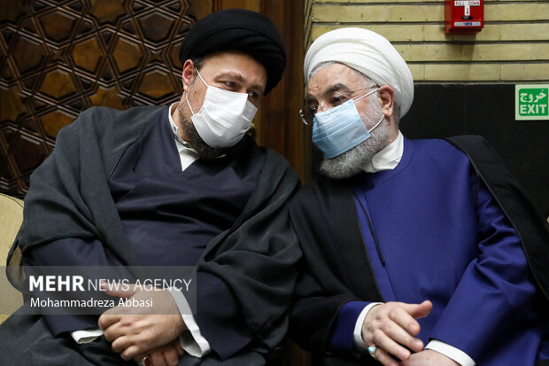 حجت الاسلام حسن روحانی رئیس دولت دوازدهم و حجت الاسلام سید حسن خمینی در حال گفتگو با یکدیگر در مراسم ترحیم حجتالاسلام سید محمود دعایی هستند