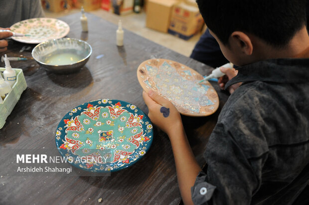یکی از کودکان کار مرکز یاسر در حال انجام کارهای هنری دستی در کارگاه است