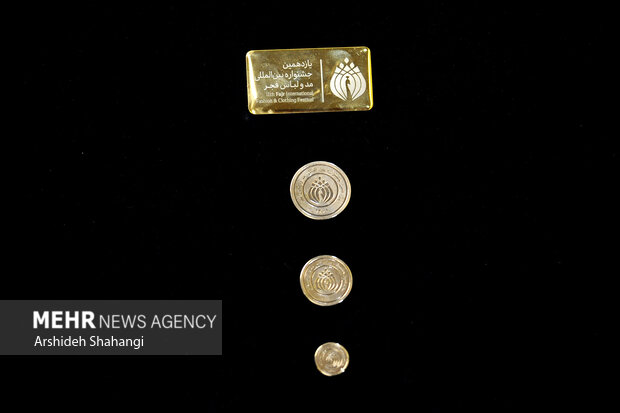 سکه های مزین به نشان یازدهمین جشنواره بین المللی مد و لباس فجر که قرار است به برگزیدگان اهدا شود در تصویر دیده می شود