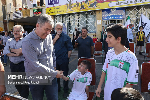 دراگان اسکوچیچ سرمربی تیم ملی فوتبال ایران در حال دست دادن با کودکان در مراسم چهارمین دوره مسابقات فوتبال جام جهانی کوچک است