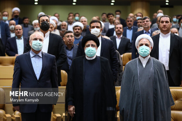 مهمانان حاظر در همایش سراسری قوه قضائیه در حال ادای احترام به سرود جمهوری اسلامی ایران هستند