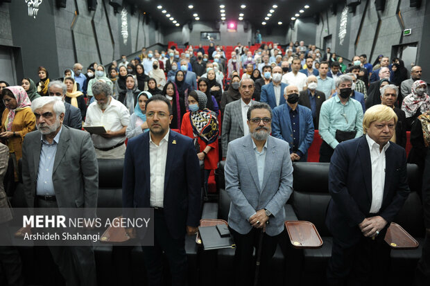 حاضرین در حال ادای احترام به سرود جمهوری اسلامی ایران در مراسم آیین نکوداشت سیدعبدالمجید شریف زاده  هستند