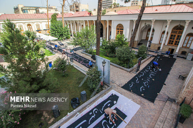 کارگاه پارچه‌نویسی عاشورایی کاتبان سوگ با حضور جمعی از هنرمندان خوشنویس در عمارت امین السلطان اتحادیه تهران در حال برگزاری است