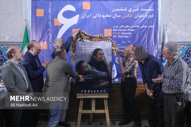 پیشکسوتان عکاسی خبری حاضر در نشست خبری ششمین دوره نشان سال عکس مطبوعاتی ایران  در حال رونمایی از پوستر این دوره جشنواره هستند