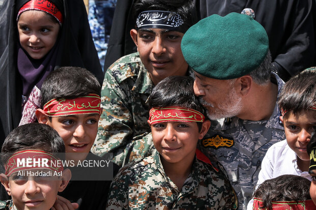 بعد از اتمام سرود امیر دریادار سیاری معاون هماهنگ کننده ارتش جمهوری اسلامی با کودکان گفتگو می کند