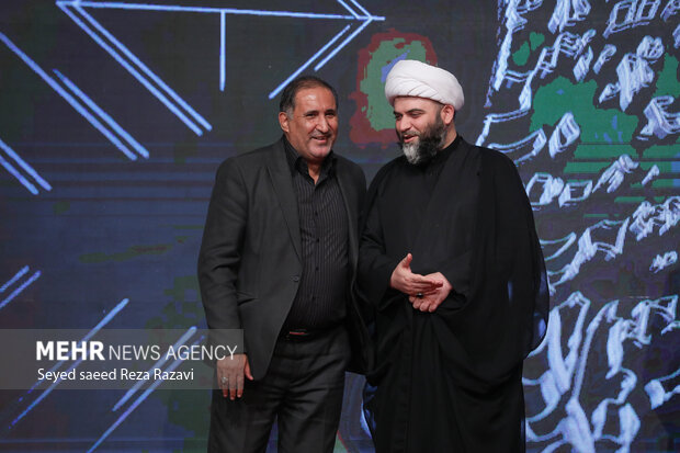 علیرضا قزوه شاعر و حجت الاسلام محمد قمی رئیس سازمان تبلیغات اسلامی در حال گفتگو با یکدیگر هستند 