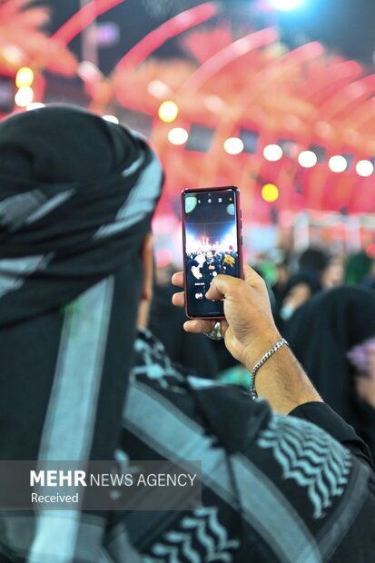 زائران اربعین سعی دارند تا با تلفن همراه خود لحظات عاشقی را با خانواده و آشنایان خود به اشتراک بگذارند. 