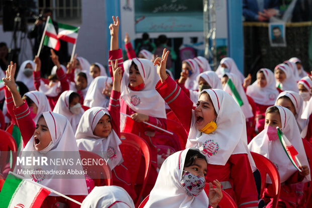 دانش آموزان در مراسم آغاز سال تحصیلی جدید با حضور رییس جمهور پرچم ایران حضور دارند