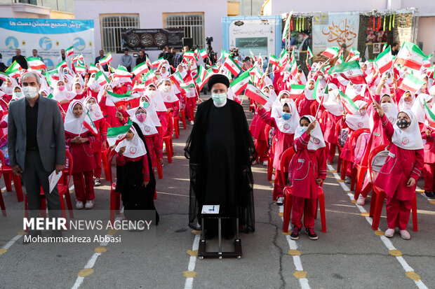 حجت الاسلام سید ابراهیم رئیسی ، رئیس جمهور در حال ادای احترام به سرود جمهوری اسلامی ایران در ابتدای مراسم آغاز سال تحصیلی جدید است
