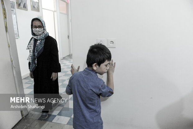 یکی از دانش آموزان نابینا مدرسه دکتر خزائلی در حال یادگیری مسیر رفت و آمد توسط مادرش در داخل مدرسه است