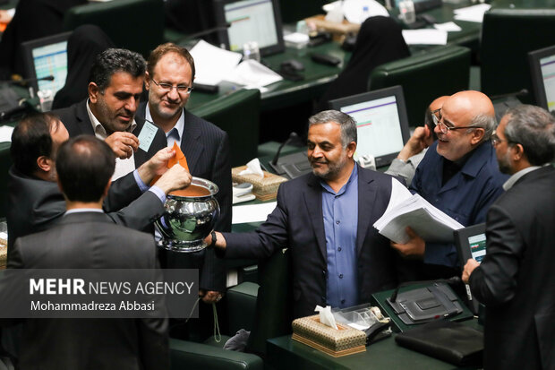 نمایندگان مجلس شورای اسلامی در حال انداختن رای های خود به گلدان های رای گیری در جلسه رای اعتماد به وزیر پیشنهادی تعاون، کار و رفاه اجتماعی هستند 