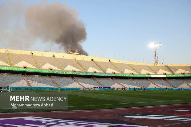 دود ناشی از آتش سوزی در پارک ارم تهران در دیدار تیم های فوتبال استقلال تهران و فولاد خوزستان در تصویر دیده می شود