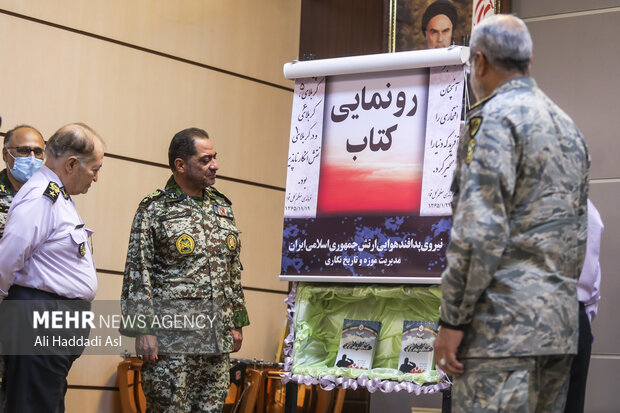 امیر احمد صادق نژاد فرمانده پدافند هوایی نیروی هوایی ارتش در حال رونمایی آثار تازه منتشر شده در  همایش علم و فن آوری در دفاع مقدس است