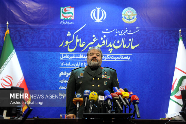 غلامرضا جلالی رئیس سازمان پدافند غیرعامل کشور در حال ادای احترام به سرود جمهوری اسلامی ایران در نشست خبری رئیس سازمان پدافند غیرعامل کشور است
