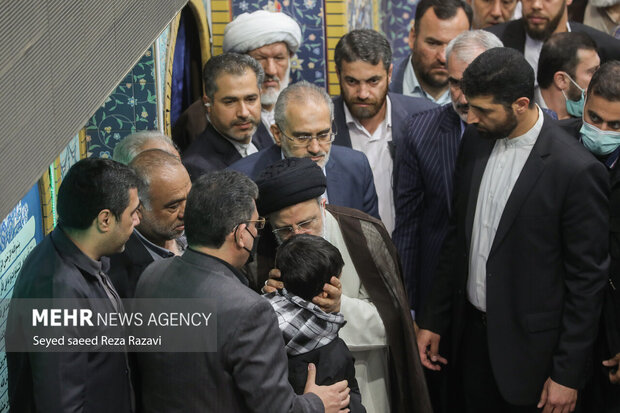 حجت الاسلام سید ابراهیم رئیسی رئیس‌جمهور در حال گفتگو با فرزند شهدای مدافع امنیت است