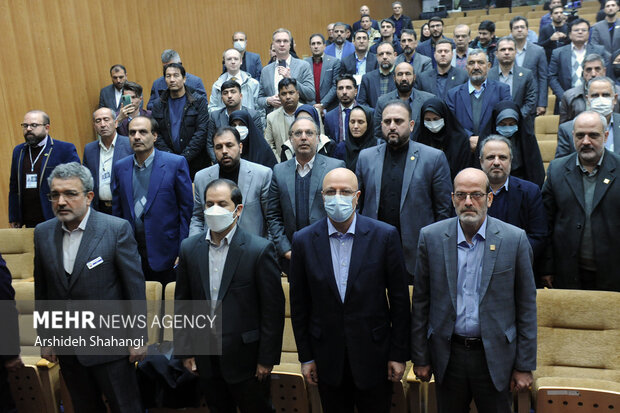 حاضرین در حال ادای احترام به سرود جمهوری اسلامی ایران در مراسم افتتاحیه بیست و سومین نمایشگاه دستاوردهای پژوهش و فناوری هستند