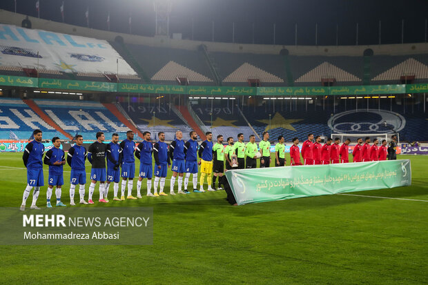 دو تیم فوتبال استقلال تهران و پرسپولیس تهران در حال انجام تشریفات پیش آغاز مسابقه هستند