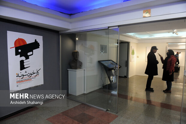 محمدحسین نیرومند در حال پاسخ دادن به سوالات خبرنگار مهر در مراسم افتتاح نمایشگاه پوستر خود است