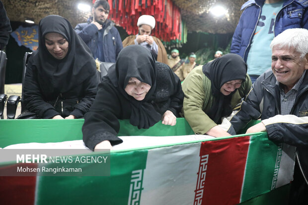 مادر شهید یونس یوسف‌زاده در حال وداع با پیکر فرزند شهید خود در معراج شهدا تهران است