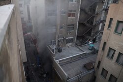 اطفا حریق ساختمان ۱۵۳ در خیابان بهار/ آتش‌نشانان مشغول لکه‌گیری هستند