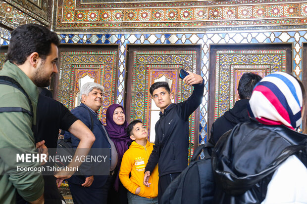 مسافران نوروزی در ایوان تخت مرمر کاخ گلستان با تزیینات زیبای این ایوان عکس یادگاری میگیرند