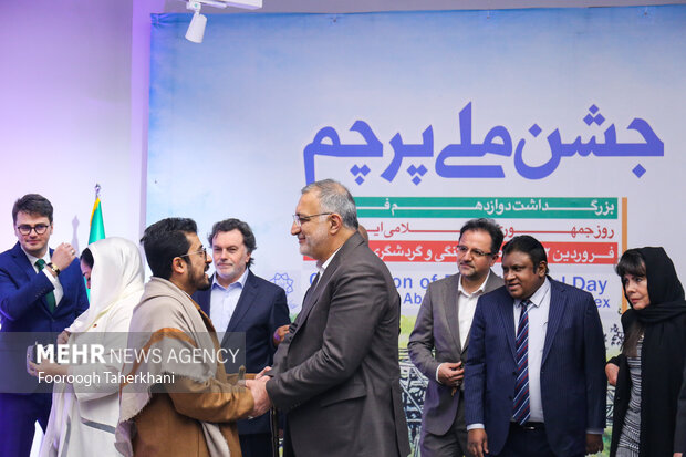 علیرضا زاکانی شهردار با نمایندگان خارجی درمراسم جشن ملی پرچم در سالن باغ هنر در حال صحبت است