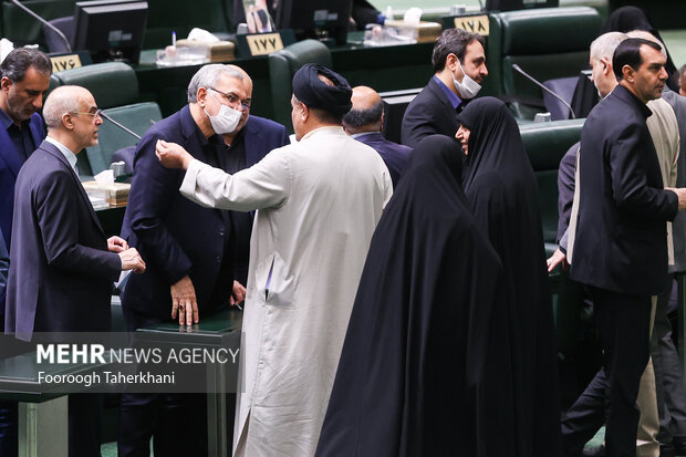بهرام عین اللهی، وزیر بهداشت در حال گفتگو با نمایندگان مجلس در صحن مجلس است