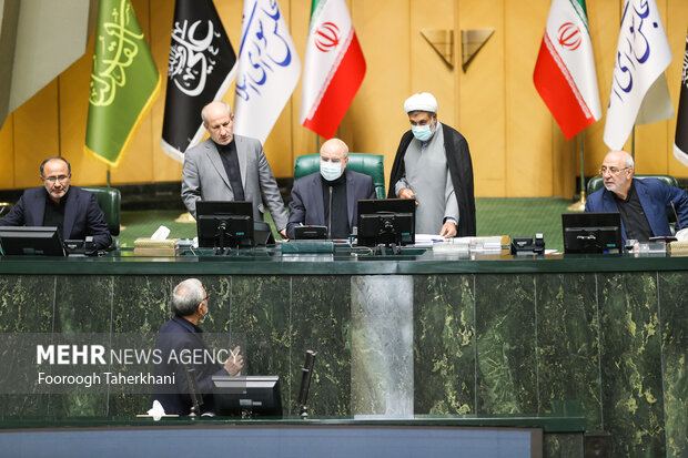 بهرام عین اللهی، وزیر بهداشت و محمدباقر قالیباف رییس مجلس در مجلس در حال صحبت با یکدیگر هستند