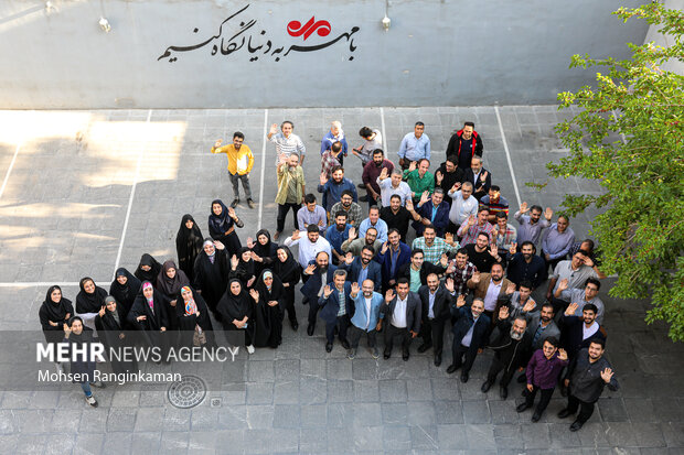 کارکنان و خبرنگاران گروه رسانه ای مهر در حال گرفتن عکس یادگاری با محمد شجاییان مدیر عامل سابق گروه رسانه ای مهر هستند