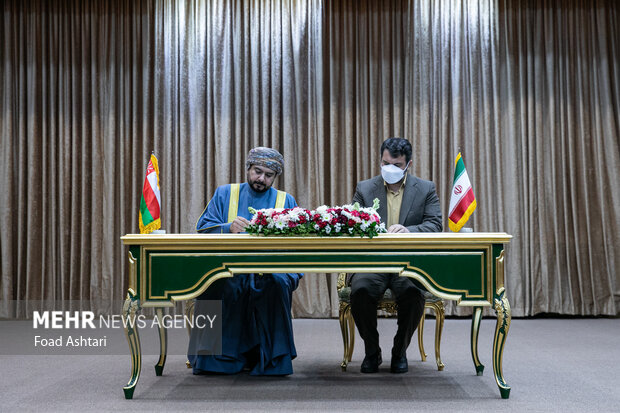 حجت عبدالملکی در حال امضای تفاهمنامه با طرف عمانی در مراسم استقبال رسمی رئیس جمهور ایران از پادشاه عمان و امضای تفاهمنامه بین دو کشور است 
