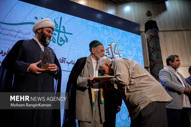 حجت الاسلام محمد قمی رئیس سازمان تبلیغات اسلامی در حال تقدیر از پیشکسوتان است